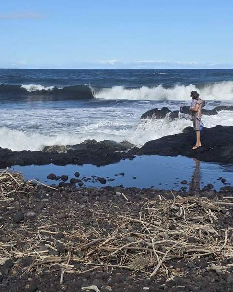 Surf breaking past a black lava shelf and tide pool
